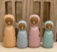 four wooden dolls in a row on a wooden table